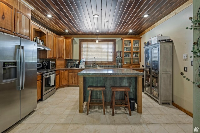 14745 N 8375 E, Spring City, UT 84662 - kitchen featuring appliances with stainless steel finishes, under cabinet range hood, brown cabinetry, open shelves, and a kitchen bar