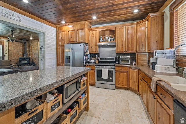 14745 N 8375 E, Spring City, UT 84662 - kitchen featuring stainless steel appliances, wood ceiling, a wood stove, under cabinet range hood, and a sink