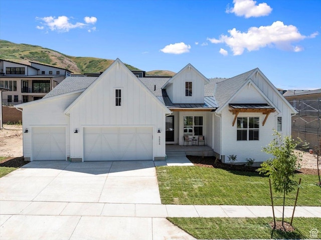 5854 N Fox Canyon Rd, Lehi, UT 84043 - modern farmhouse style home with a standing seam roof, board and batten siding, concrete driveway, and roof with shingles