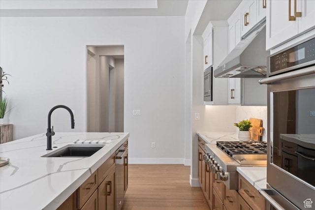 5854 N Fox Canyon Rd, Lehi, UT 84043 - kitchen featuring a sink, appliances with stainless steel finishes, under cabinet range hood, light wood-style flooring, and baseboards