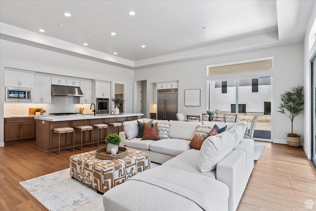 5854 N Fox Canyon Rd, Lehi, UT 84043 - living area with a raised ceiling, recessed lighting, light wood-type flooring, and baseboards