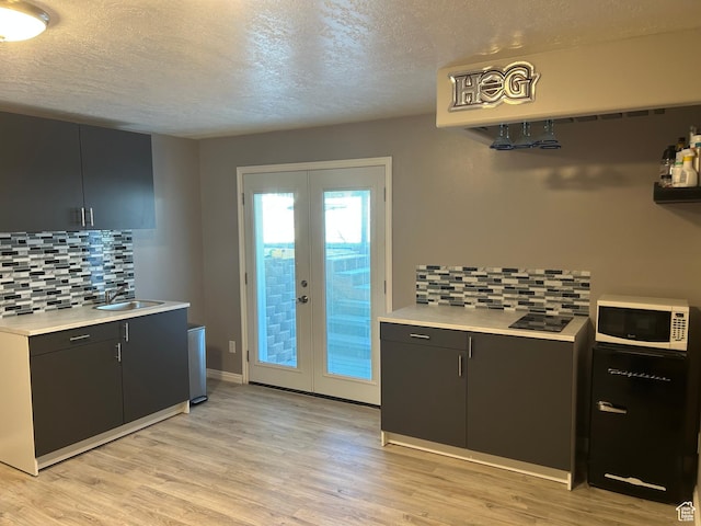 5029 W Copper Meadow Ln S, West Jordan, UT 84088 - kitchen with white microwave, french doors, a textured ceiling, light countertops, and light wood finished floors