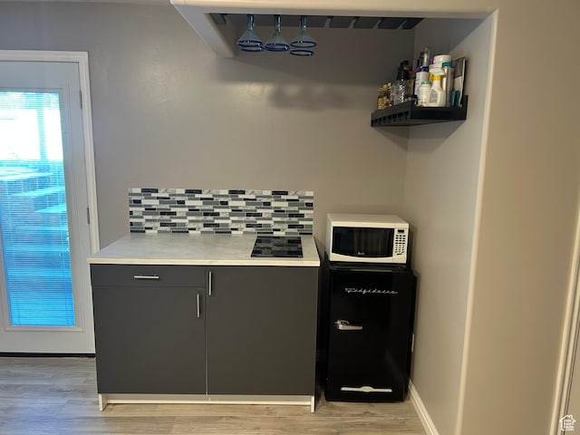 5029 W Copper Meadow Ln S, West Jordan, UT 84088 - kitchen featuring white microwave, tasteful backsplash, light wood-type flooring, and light countertops