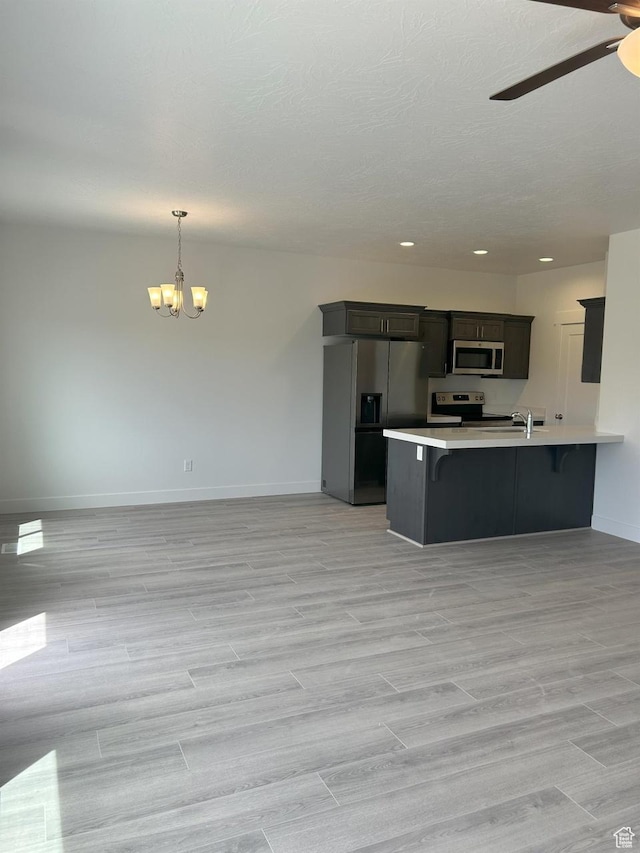 5118 E Lakefield Dr N, Eagle Mountain, UT 84005 - kitchen with stainless steel appliances, a chandelier, light countertops, a ceiling fan, and baseboards