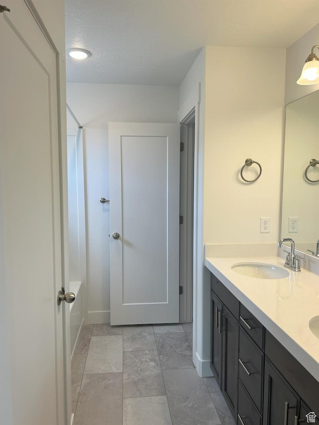 5118 E Lakefield Dr N, Eagle Mountain, UT 84005 - bathroom featuring double vanity, shower / tub combination, and baseboards