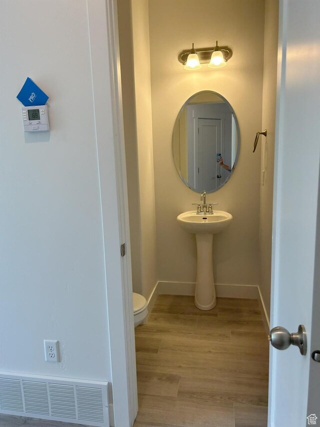 5118 E Lakefield Dr N, Eagle Mountain, UT 84005 - half bath featuring wood finished floors, toilet, and baseboards