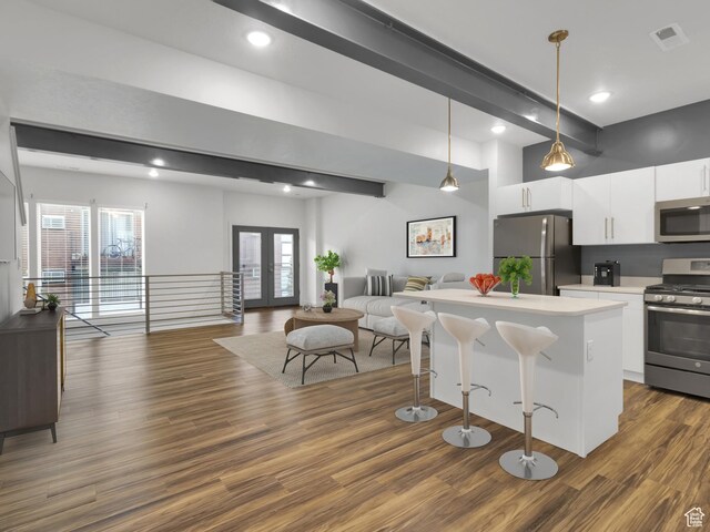 1618 E 3300 S, Millcreek, UT 84106 - kitchen with stainless steel appliances, open floor plan, white cabinetry, a breakfast bar, and beam ceiling