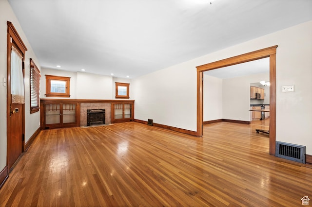 1636 S 1400 E, Salt Lake City, UT 84105 - unfurnished living room featuring wood finished floors, baseboards, a fireplace with flush hearth, and recessed lighting