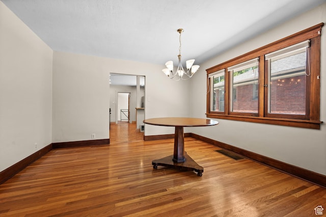 1636 S 1400 E, Salt Lake City, UT 84105 - unfurnished dining area with baseboards, wood finished floors, and a chandelier