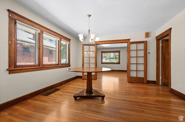 1636 S 1400 E, Salt Lake City, UT 84105 - unfurnished dining area with a chandelier, plenty of natural light, baseboards, and wood finished floors