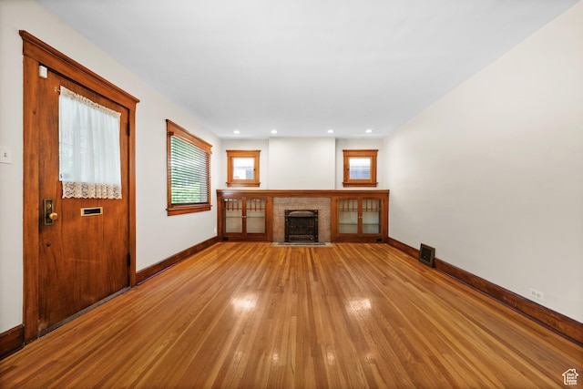 1636 S 1400 E, Salt Lake City, UT 84105 - unfurnished living room featuring light wood-style floors, baseboards, a brick fireplace, and recessed lighting