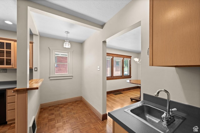 1636 S 1400 E, Salt Lake City, UT 84105 - kitchen with a sink, baseboards, glass insert cabinets, decorative light fixtures, and wood counters