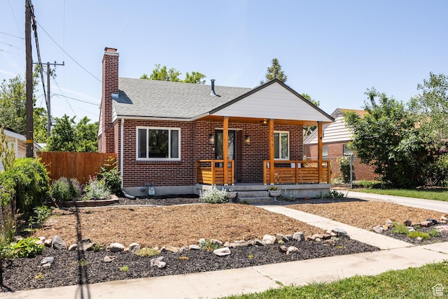 1217 Talisman Dr, Salt Lake City, UT 84116 - view of front of house with a porch, brick siding, a chimney, and roof with shingles