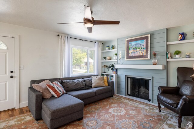 1217 Talisman Dr, Salt Lake City, UT 84116 - living area featuring a ceiling fan, wood finished floors, a fireplace, and a textured ceiling