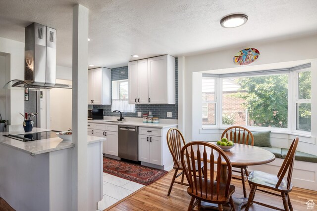 1217 Talisman Dr, Salt Lake City, UT 84116 - kitchen with dishwasher, island exhaust hood, backsplash, black electric stovetop, and white cabinetry