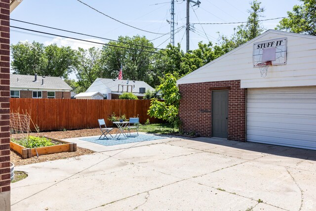 1217 Talisman Dr, Salt Lake City, UT 84116 - view of patio / terrace featuring driveway, a garden, and an outbuilding