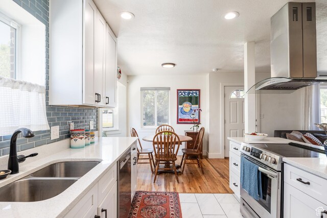 1217 Talisman Dr, Salt Lake City, UT 84116 - kitchen featuring wall chimney range hood, stainless steel appliances, a sink, healthy amount of natural light, and recessed lighting