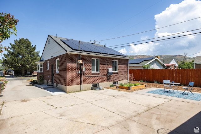 1217 Talisman Dr, Salt Lake City, UT 84116 - back of property featuring a patio, solar panels, and brick siding