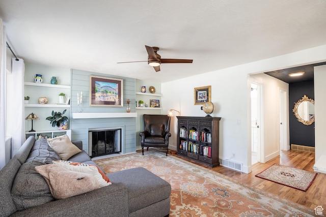 1217 Talisman Dr, Salt Lake City, UT 84116 - living area with wood finished floors, a fireplace, ceiling fan, and built in features