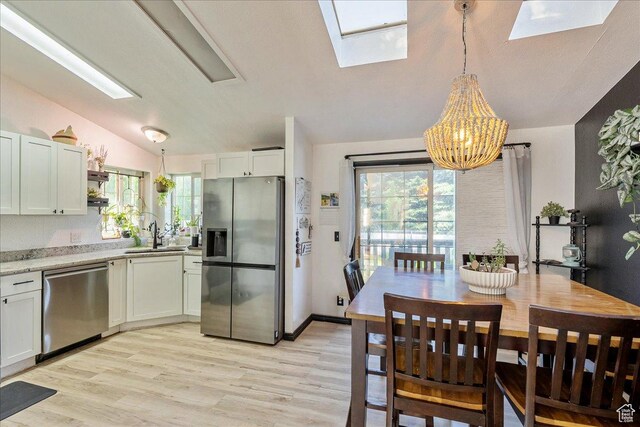 1687 Kylee Ln, Ogden, UT 84404 - kitchen featuring stainless steel appliances, a skylight, lofted ceiling, a sink, and a chandelier