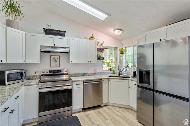 1687 Kylee Ln, Ogden, UT 84404 - kitchen with appliances with stainless steel finishes, under cabinet range hood, lofted ceiling, a sink, and white cabinetry