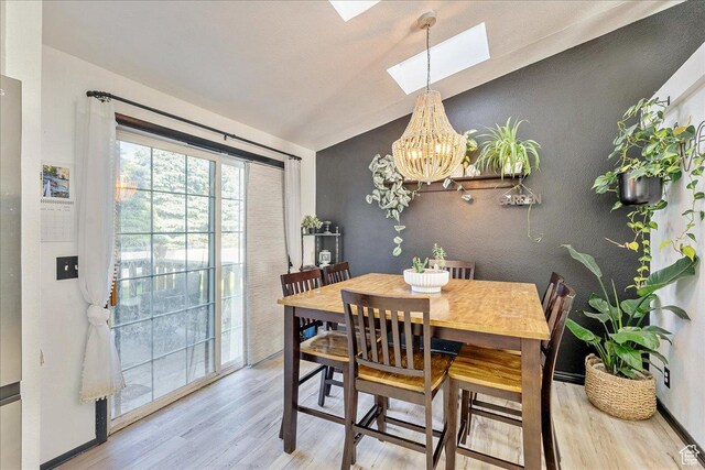 1687 Kylee Ln, Ogden, UT 84404 - dining area with a skylight, wood finished floors, vaulted ceiling, a chandelier, and baseboards