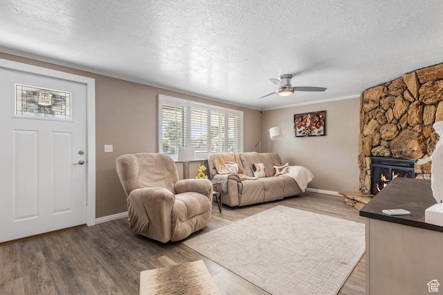 8265 S 3450 W, West Jordan, UT 84088 - living room featuring a textured ceiling, ceiling fan, baseboards, wood finished floors, and a stone fireplace