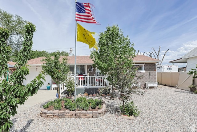 8265 S 3450 W, West Jordan, UT 84088 - view of property hidden behind natural elements featuring brick siding, a porch, and a garage