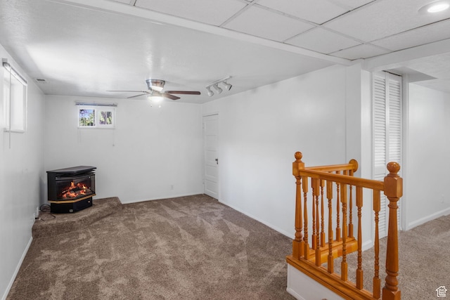 1979 S 600 E, Salt Lake City, UT 84105 - carpeted spare room with a wood stove, ceiling fan, rail lighting, and baseboards