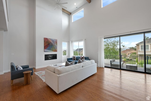 7862 S Danish Pine Ln, Salt Lake City, UT 84121 - living area with wood finished floors, a towering ceiling, ceiling fan, baseboards, and beam ceiling