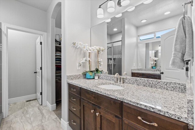 3352 N 200 W, Lehi, UT 84043 - full bath featuring a shower stall, a walk in closet, vanity, baseboards, and marble look tiles