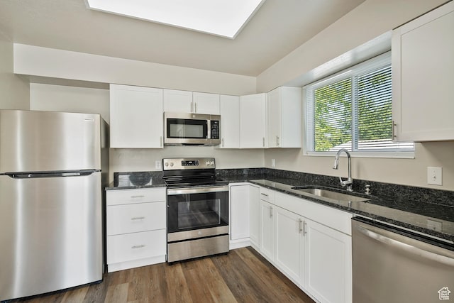 221 N Pingree Ave E, Ogden, UT 84404 - kitchen with stainless steel appliances, a sink, dark stone countertops, white cabinets, and dark wood-style flooring