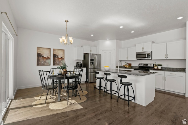 464 S Highpoint Dr, Saratoga Springs, UT 84045 - kitchen featuring stainless steel appliances, dark wood finished floors, a breakfast bar area, a chandelier, and white cabinets