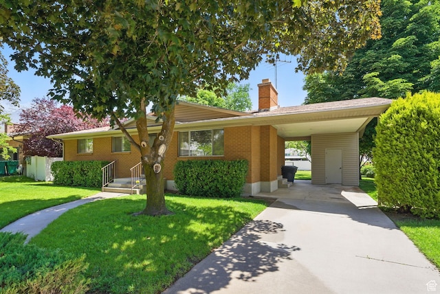 232 N 600 E, Orem, UT 84097 - view of front of property with concrete driveway, a chimney, a front yard, brick siding, and an attached carport