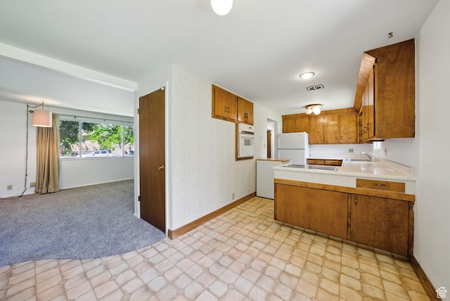 232 N 600 E, Orem, UT 84097 - kitchen featuring white appliances, a sink, brown cabinetry, light countertops, and a peninsula