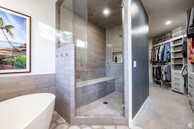5972 S Ragsdale Dr, Murray, UT 84121 - bathroom featuring a freestanding tub, a shower stall, a walk in closet, recessed lighting, and tile walls