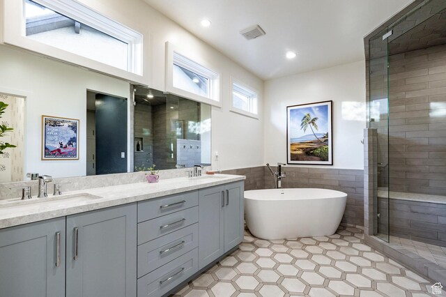 5972 S Ragsdale Dr, Murray, UT 84121 - bathroom featuring double vanity, a freestanding tub, tile walls, a stall shower, and tile patterned floors