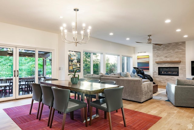 5972 S Ragsdale Dr, Murray, UT 84121 - dining space featuring a chandelier, a stone fireplace, recessed lighting, light wood-style floors, and ceiling fan