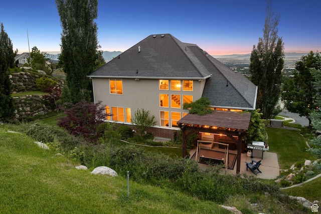 603 S Temple Hill Cir E, Bountiful, UT 84010 - back of house at dusk featuring a patio and stucco siding