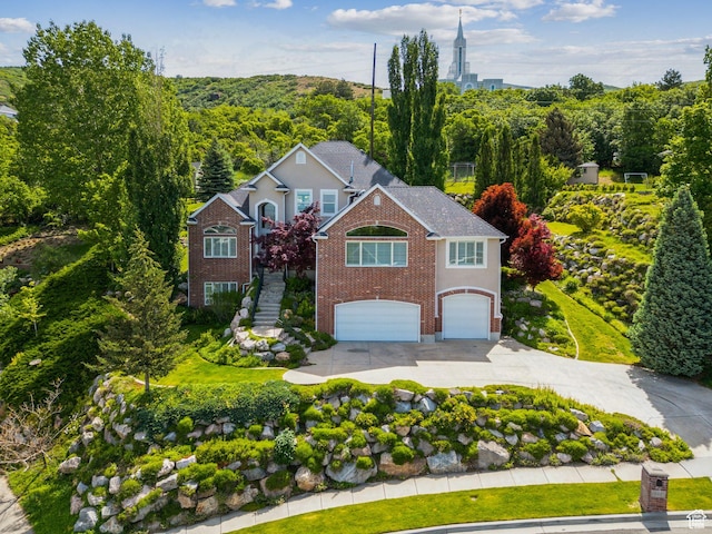 603 S Temple Hill Cir E, Bountiful, UT 84010 - traditional home with driveway, a garage, brick siding, and stairway
