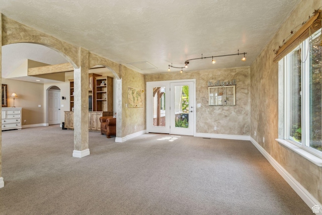 603 S Temple Hill Cir E, Bountiful, UT 84010 - unfurnished living room with arched walkways, baseboards, carpet flooring, and a textured ceiling