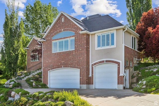 603 S Temple Hill Cir E, Bountiful, UT 84010 - view of front of home with a garage, concrete driveway, brick siding, stairs, and stucco siding