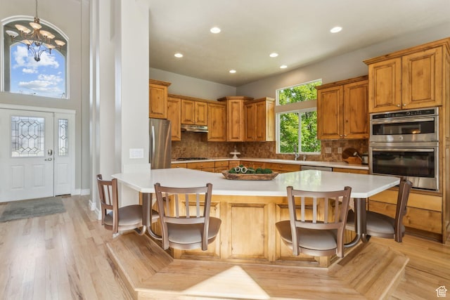 603 S Temple Hill Cir E, Bountiful, UT 84010 - kitchen with appliances with stainless steel finishes, under cabinet range hood, recessed lighting, light countertops, and a kitchen breakfast bar