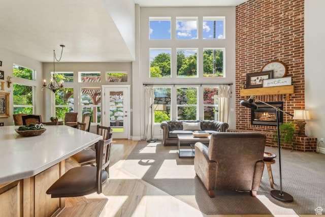 603 S Temple Hill Cir E, Bountiful, UT 84010 - living area with a fireplace, a high ceiling, a chandelier, healthy amount of natural light, and wood finished floors