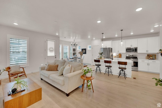 11693 S Watercourse Rd, South Jordan, UT 84009 - living room featuring recessed lighting, a chandelier, light wood-type flooring, and baseboards