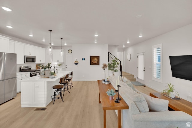 11693 S Watercourse Rd, South Jordan, UT 84009 - living area featuring recessed lighting, light wood finished floors, stairway, and baseboards