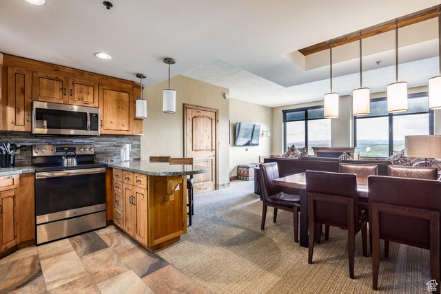 3855 Grand Summit Dr Unit 214Q1, Park City, UT 84098 - kitchen featuring stainless steel appliances, brown cabinets, open floor plan, a peninsula, and decorative backsplash