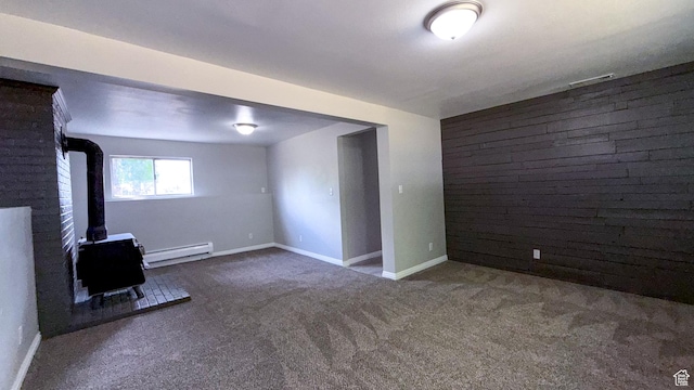 230 S 700 W, Price, UT 84501 - carpeted spare room featuring a wood stove, a baseboard heating unit, an accent wall, and baseboards