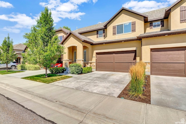 7259 S Viansa Ct, Midvale, UT 84047 - view of front of property with stucco siding, a garage, driveway, stone siding, and a porch