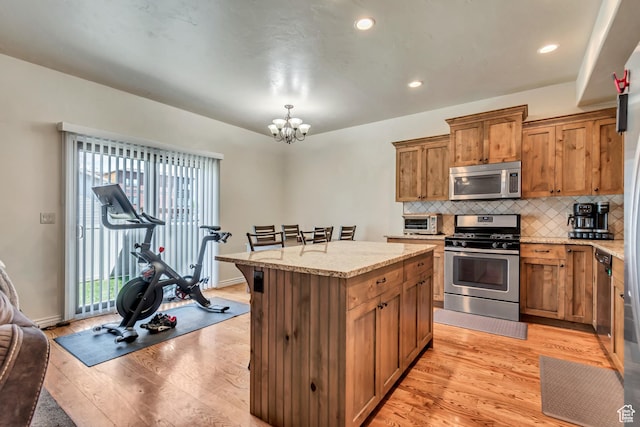 7259 S Viansa Ct, Midvale, UT 84047 - kitchen with appliances with stainless steel finishes, light wood-style floors, a chandelier, backsplash, and recessed lighting